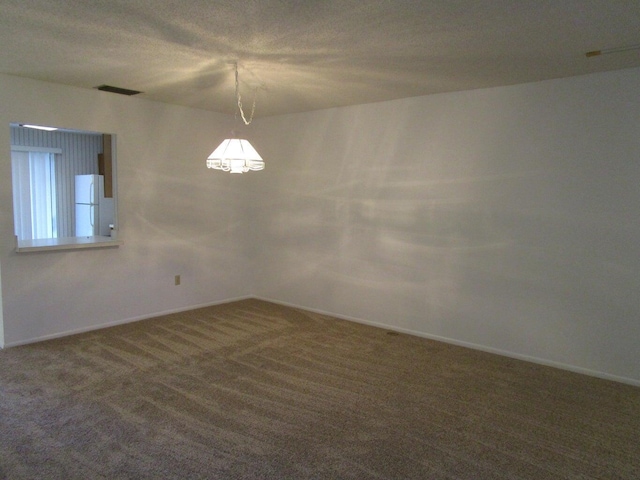 spare room featuring visible vents, baseboards, and carpet floors
