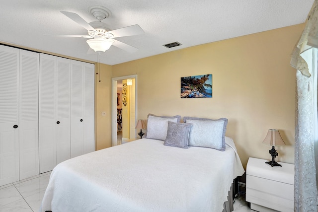 bedroom with ceiling fan, a closet, and visible vents