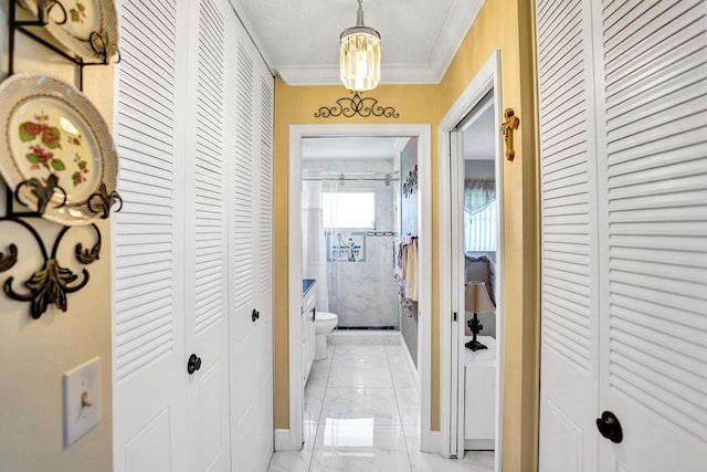 corridor with marble finish floor, baseboards, and ornamental molding