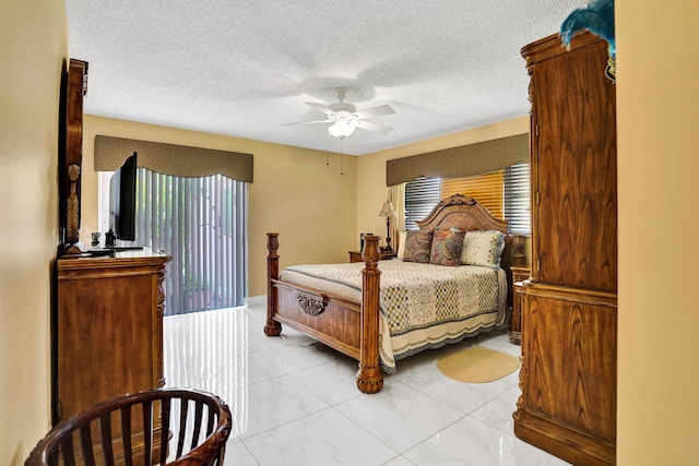 bedroom featuring a textured ceiling, marble finish floor, and ceiling fan