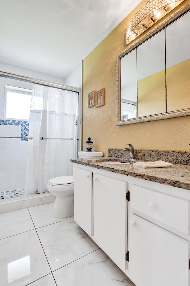 bathroom featuring vanity, toilet, a shower stall, and a textured wall
