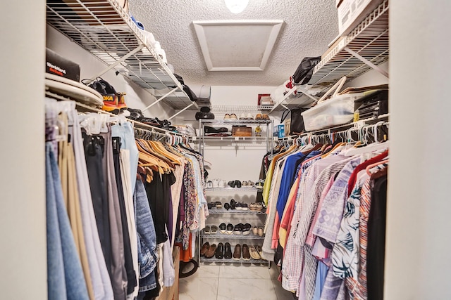 spacious closet with attic access and marble finish floor