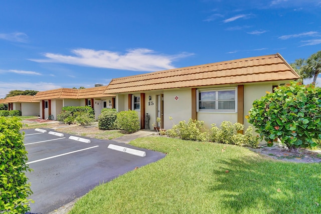 5730 Fernley Dr E Unit 15, West Palm Beach, FL 33415 - ranch-style house with a front lawn, a tiled roof, uncovered parking, and stucco siding