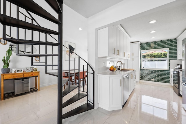 interior space featuring baseboards, stairway, recessed lighting, a sink, and appliances with stainless steel finishes