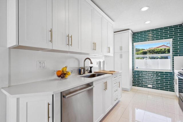 kitchen with white cabinets, a sink, dishwasher, light countertops, and light tile patterned floors