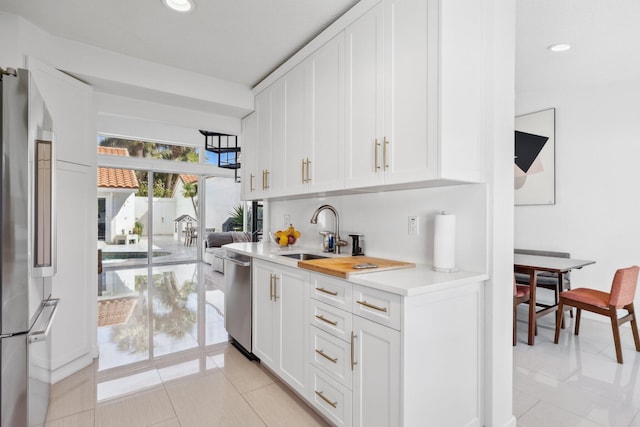 bar with a sink, appliances with stainless steel finishes, light tile patterned floors, and recessed lighting