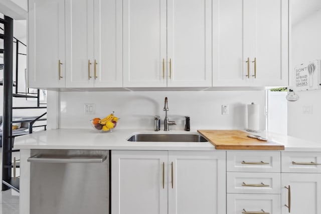 kitchen with white cabinets, a sink, and dishwasher