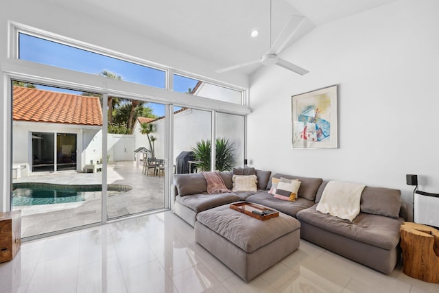 living area with a ceiling fan, recessed lighting, and a towering ceiling