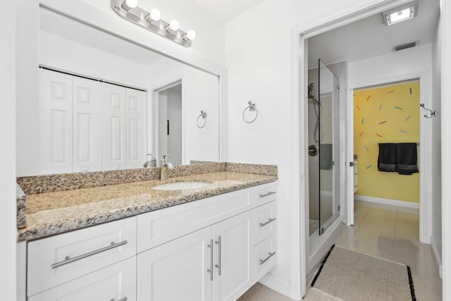 bathroom featuring visible vents, a stall shower, vanity, baseboards, and toilet