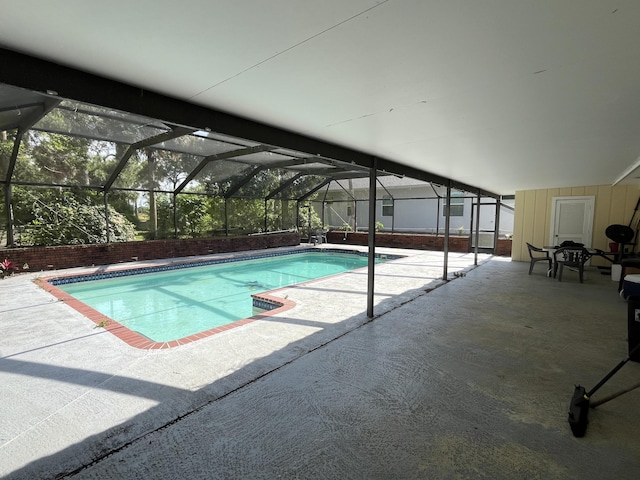 outdoor pool featuring a patio area and glass enclosure