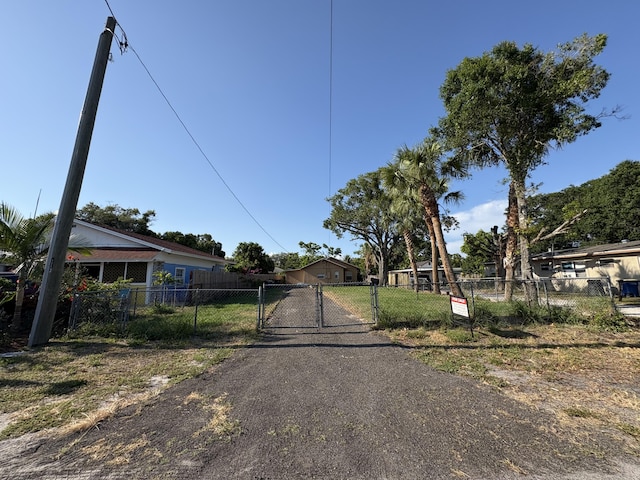 view of street with driveway, a gated entry, and a gate
