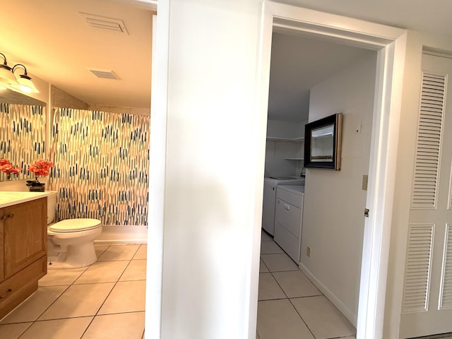 bathroom featuring washing machine and clothes dryer, tile patterned floors, a shower, vanity, and toilet
