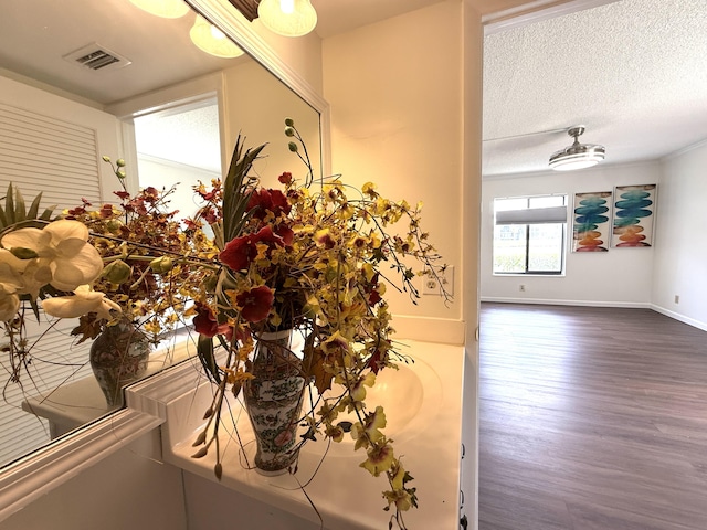 detailed view of wood finished floors, a textured ceiling, and baseboards