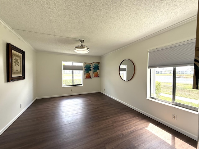 empty room featuring crown molding, a textured ceiling, dark wood finished floors, and baseboards