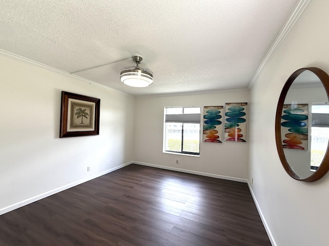 empty room with dark wood-style flooring, crown molding, a textured ceiling, and baseboards