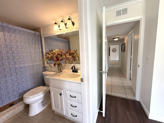 bathroom with toilet, vanity, a shower with shower curtain, and tile patterned floors