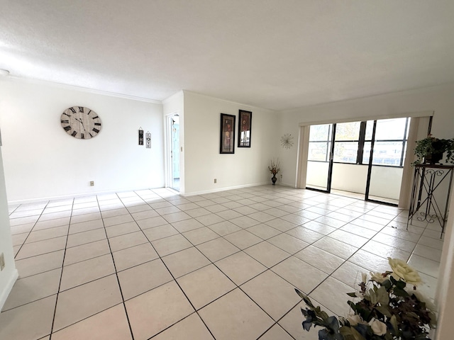 unfurnished room featuring light tile patterned floors, crown molding, and baseboards