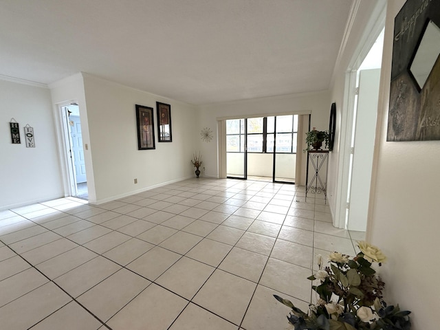 unfurnished room featuring light tile patterned floors, crown molding, and baseboards