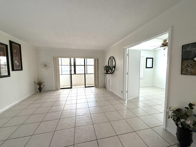 empty room featuring crown molding, light tile patterned floors, a ceiling fan, and baseboards