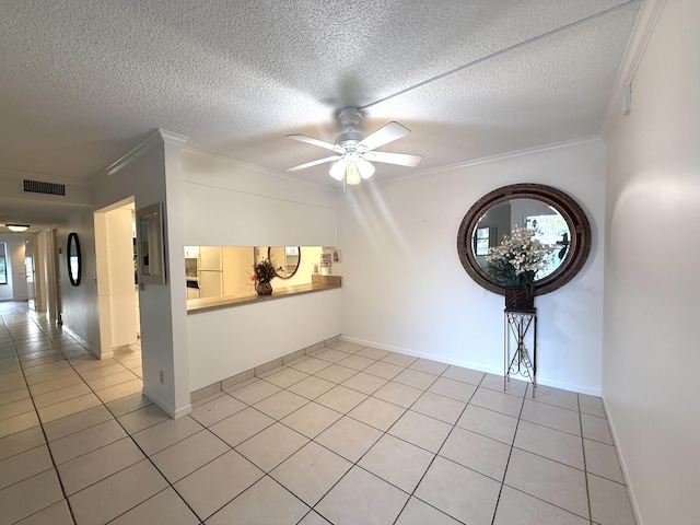 unfurnished room featuring ornamental molding, light tile patterned flooring, a ceiling fan, a textured ceiling, and baseboards