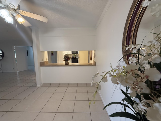 foyer entrance with ceiling fan, ornamental molding, light tile patterned floors, a textured ceiling, and baseboards