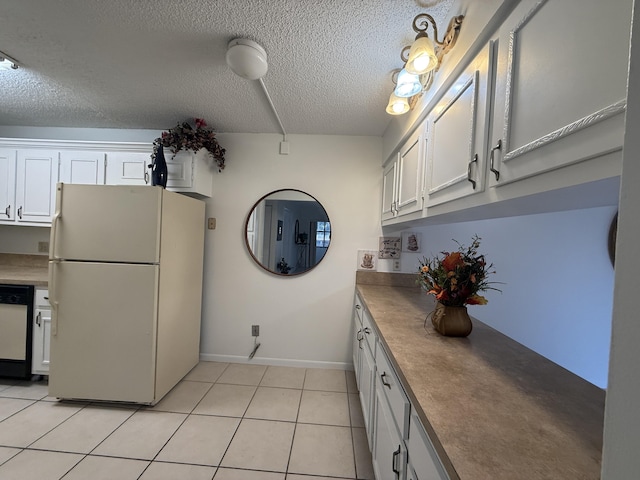 kitchen featuring freestanding refrigerator, dishwasher, a textured ceiling, white cabinetry, and baseboards