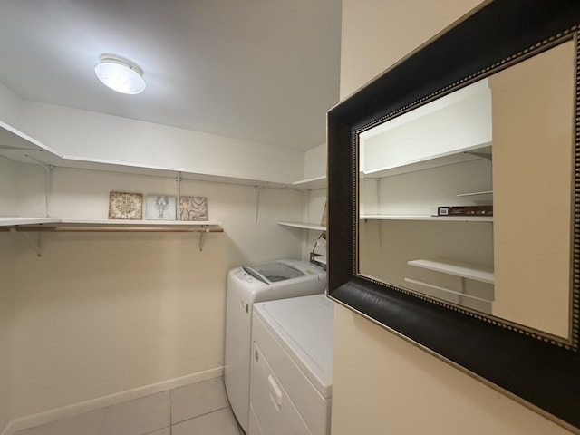 laundry room with separate washer and dryer, light tile patterned floors, and baseboards