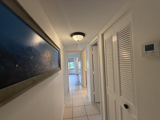 hallway with light tile patterned floors and baseboards