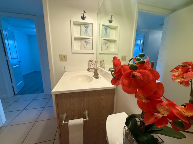 half bathroom featuring tile patterned floors and vanity