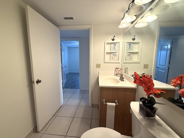 bathroom with tile patterned flooring, toilet, vanity, and baseboards