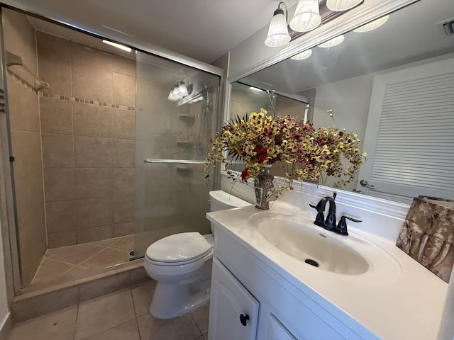 bathroom featuring toilet, a stall shower, vanity, and tile patterned floors
