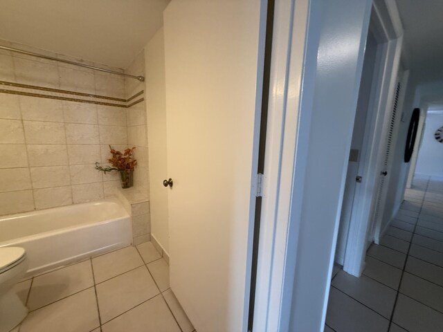 full bath featuring tile patterned floors, toilet, and shower / tub combination