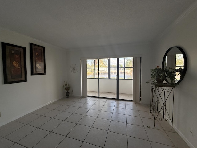spare room with ornamental molding and light tile patterned flooring