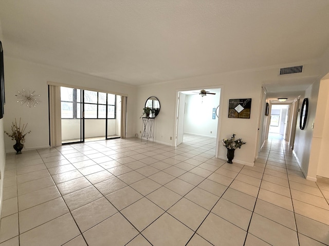 empty room featuring light tile patterned floors, plenty of natural light, ceiling fan, and baseboards