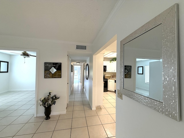 hallway featuring ornamental molding, light tile patterned floors, and baseboards