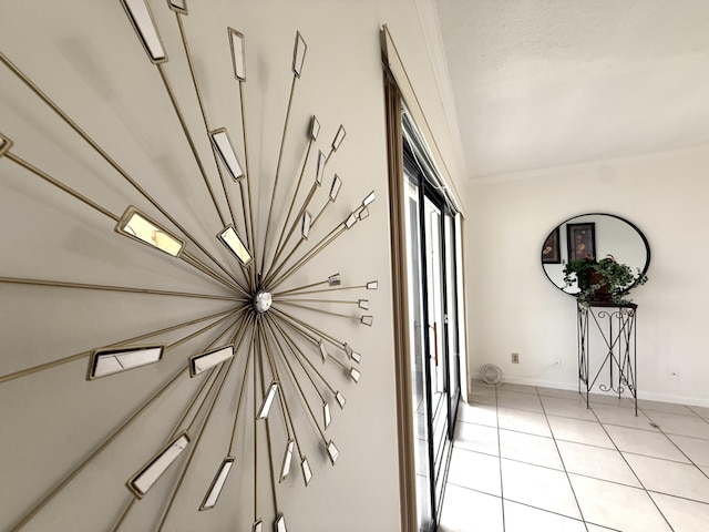 corridor featuring light tile patterned floors, crown molding, and baseboards
