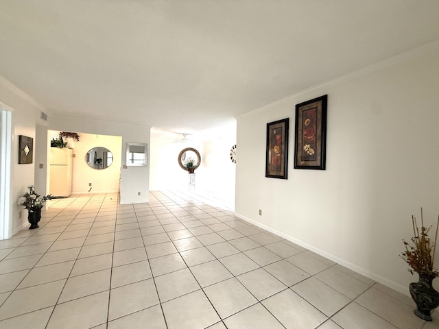 empty room with crown molding and light tile patterned floors
