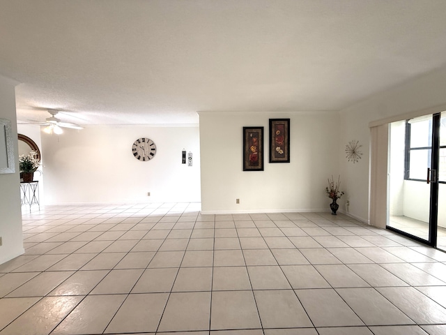 spare room with a ceiling fan and light tile patterned flooring