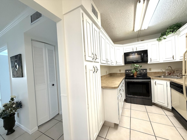 kitchen featuring black appliances, light tile patterned floors, a sink, white cabinets, and a textured ceiling