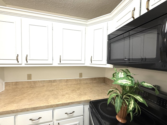 kitchen featuring black appliances, light countertops, white cabinetry, and a textured ceiling