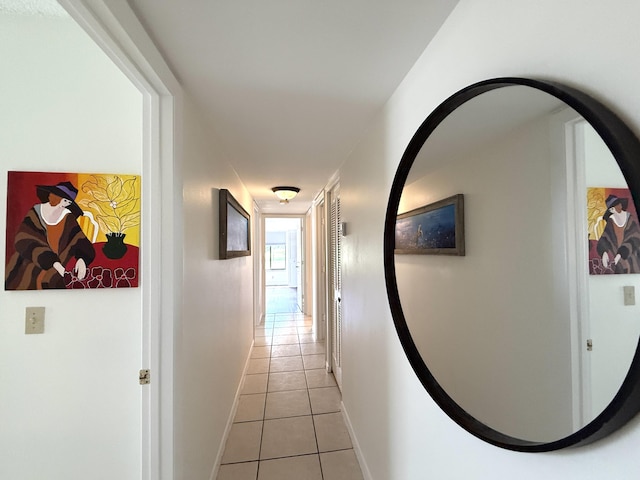 corridor featuring light tile patterned floors and baseboards