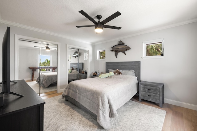 19100 SE County Line Rd, Jupiter, FL 33469 - bedroom featuring two closets, ornamental molding, light wood-style floors, baseboards, and a ceiling fan