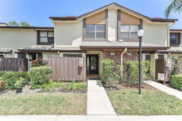 view of property featuring fence private yard and stucco siding