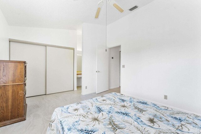 bedroom featuring light colored carpet, a ceiling fan, visible vents, and a closet