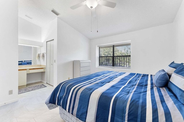 bedroom with a ceiling fan, a textured ceiling, visible vents, and vaulted ceiling