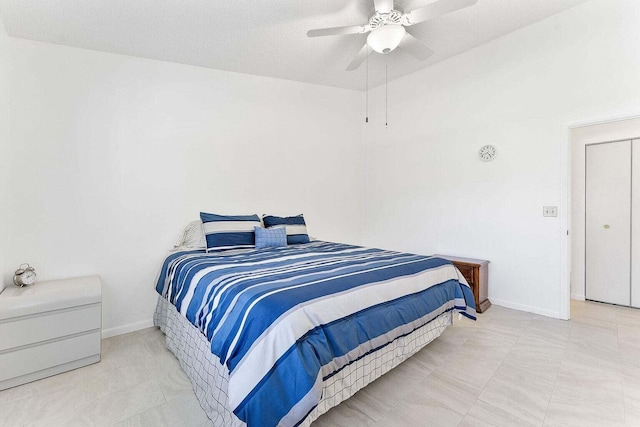 bedroom featuring baseboards, ceiling fan, and a textured ceiling