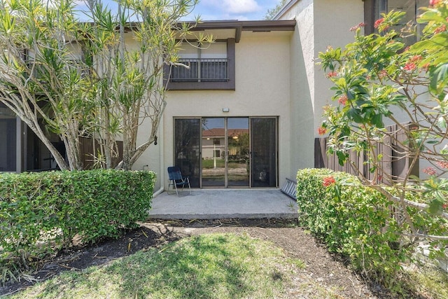 doorway to property with a patio and stucco siding