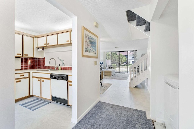 kitchen featuring white dishwasher, a sink, light countertops, a textured ceiling, and decorative backsplash