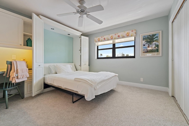 bedroom with light colored carpet, baseboards, ceiling fan, and a closet