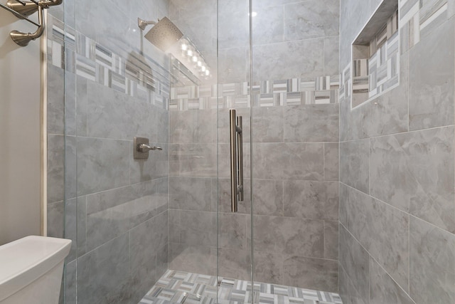 bathroom with a stall shower and toilet